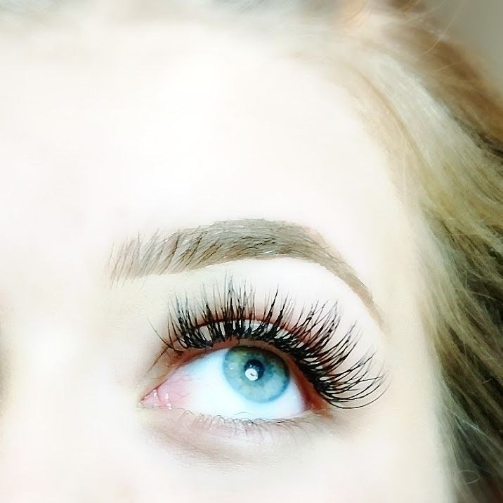 Close-up of natural-length eyelash extensions on a guest with blue eyes